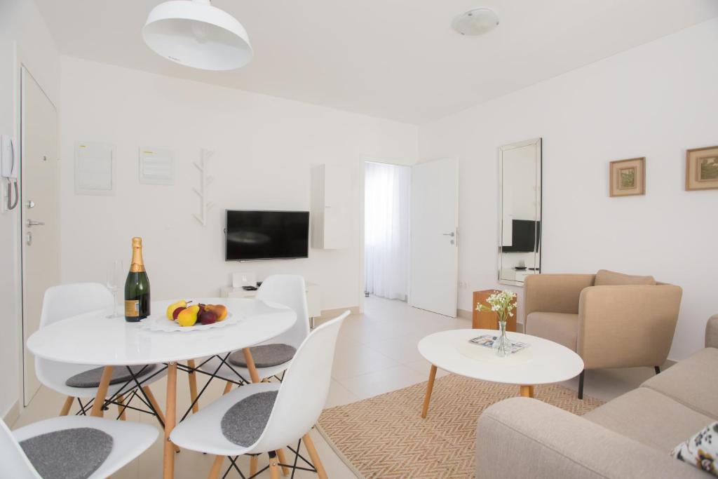 a white living room with white tables and chairs at green pine in Primošten