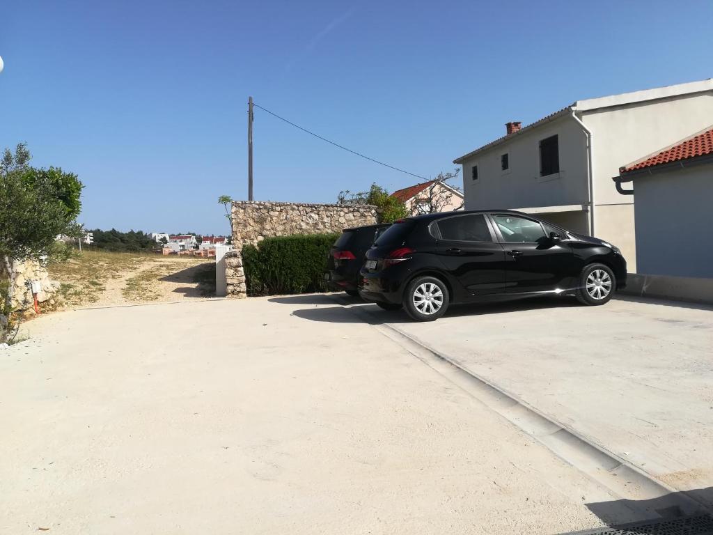 a black car parked in a parking lot at Apartments Antica in Šimuni