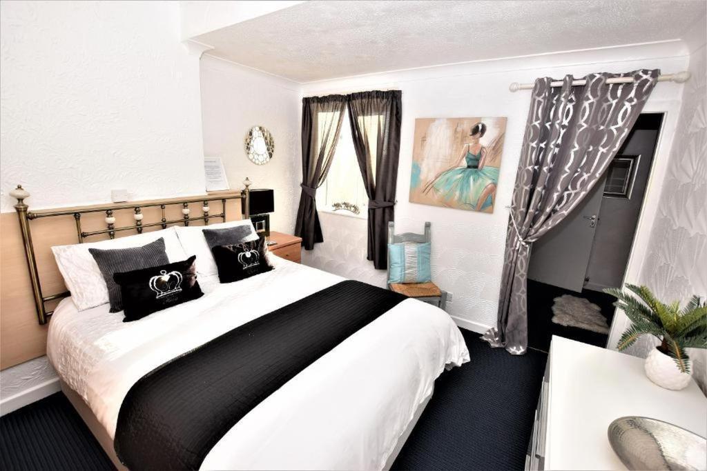 a bedroom with a large bed with black and white pillows at Bridle Lodge Apartments in Blackpool