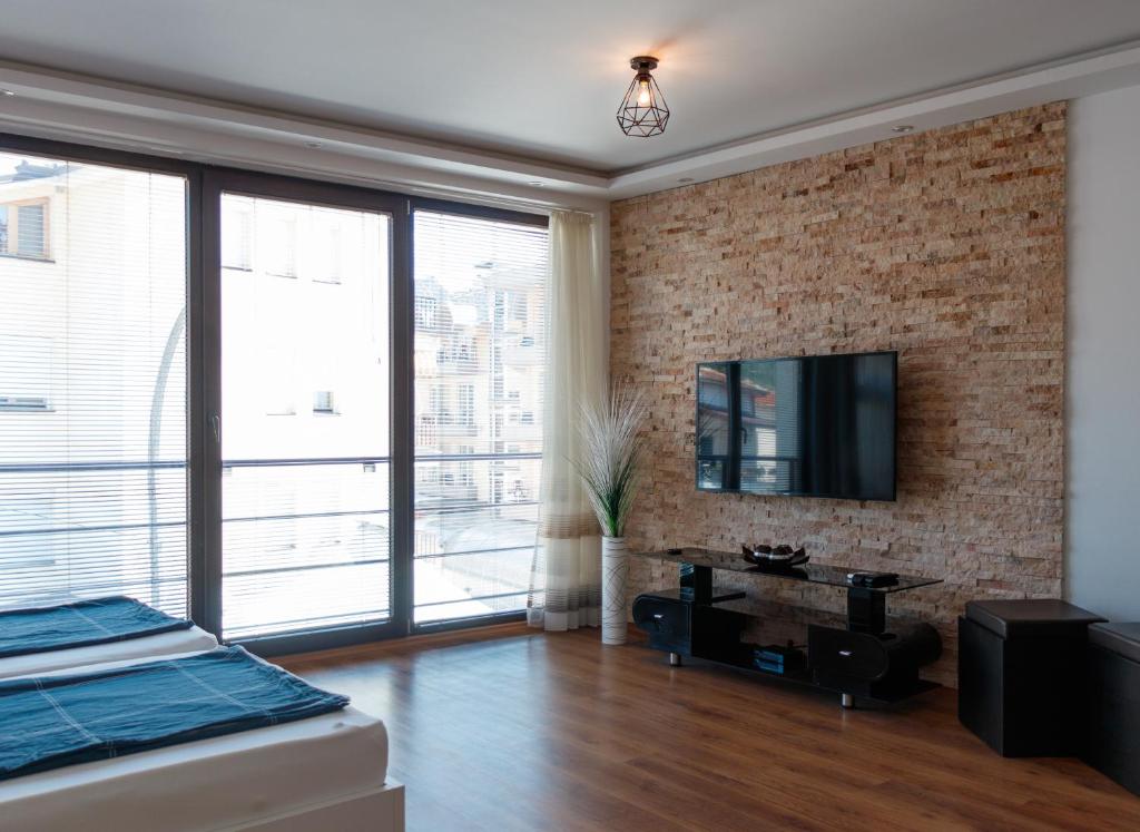 a bedroom with a brick wall and a tv at Ana's Apartments in Ohrid