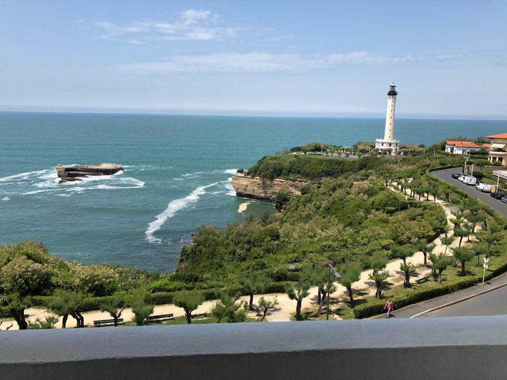 Ein Leuchtturm auf einem Hügel neben dem Meer in der Unterkunft Studio 3* Vue Mer Parking Régina et Golf in Biarritz