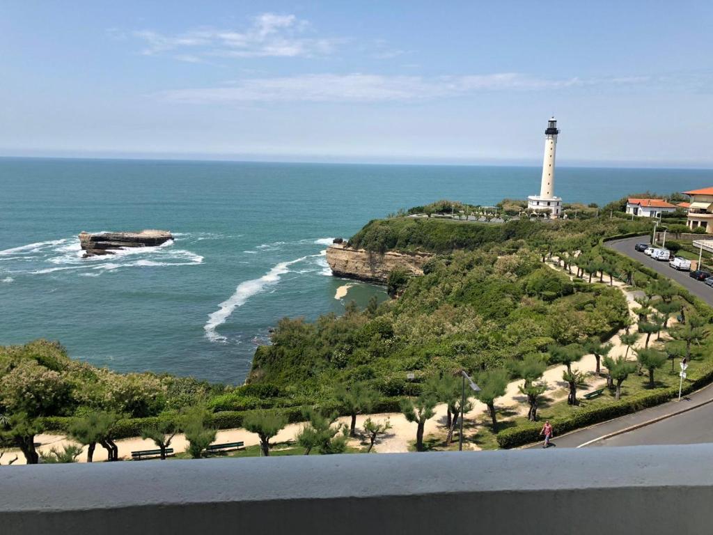 un phare sur une colline à côté de l'océan dans l'établissement Studio 3* Vue Mer Parking Régina et Golf, à Biarritz