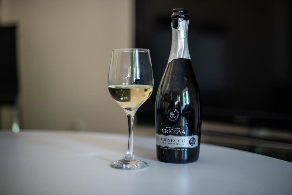 a bottle of white wine next to a glass at Apartamenty Marynarki Wojennej, Dziwnów in Dziwnów