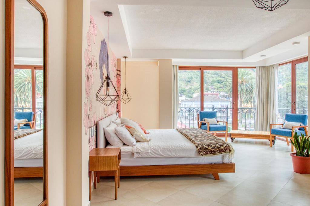 a bedroom with a large bed and a large window at Selina Baños in Baños