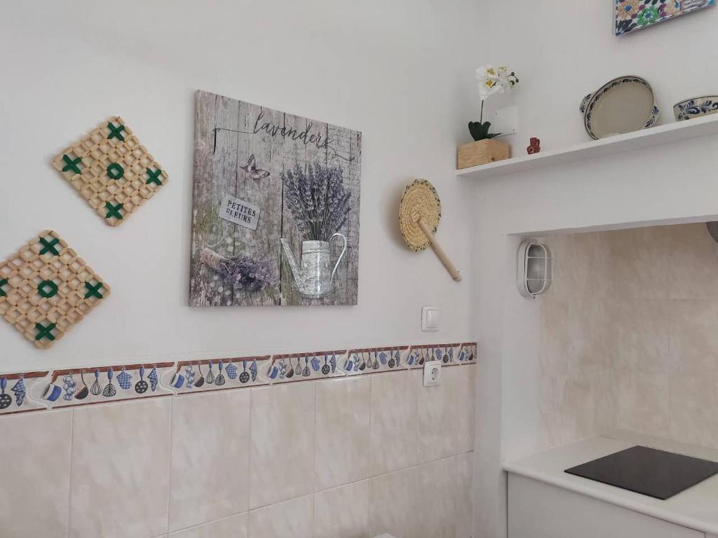 une cuisine blanche avec une photo sur le mur dans l'établissement Paço da Rainha Apartment, à Lisbonne