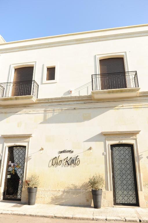 a building with a sign on the side of it at Olo Kalò Locanda in Corigliano dʼOtranto