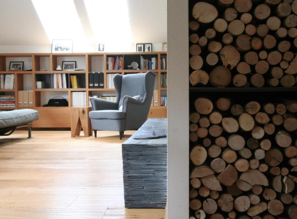 a living room with a chair and a stack of logs at Village House in Železniki