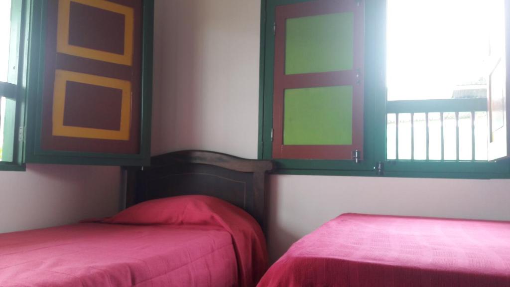 a room with two beds and a window at Hostal Casa de Los Taitas in Salento