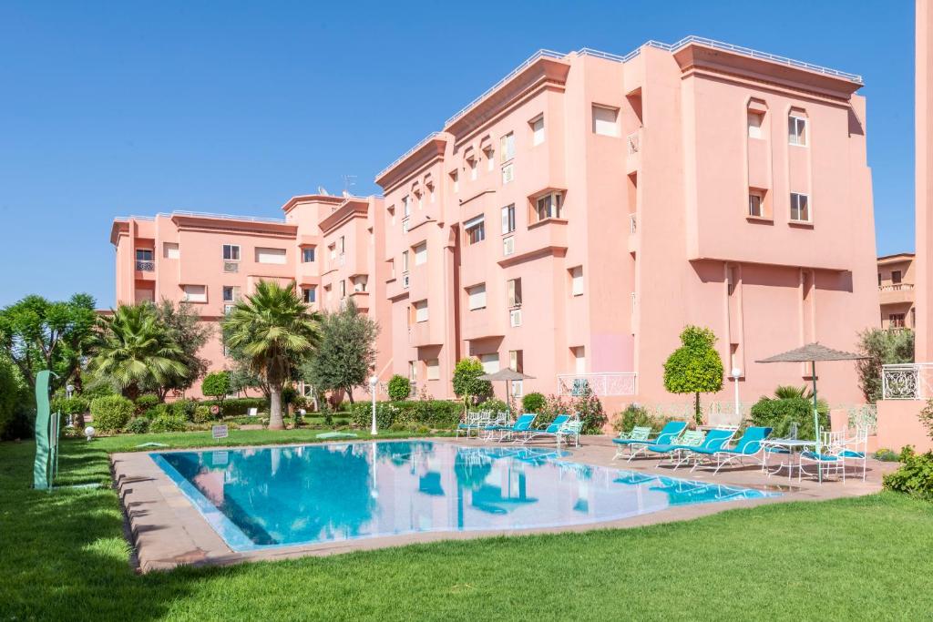 a building with a swimming pool in front of a building at Majorelle family residence in Marrakesh