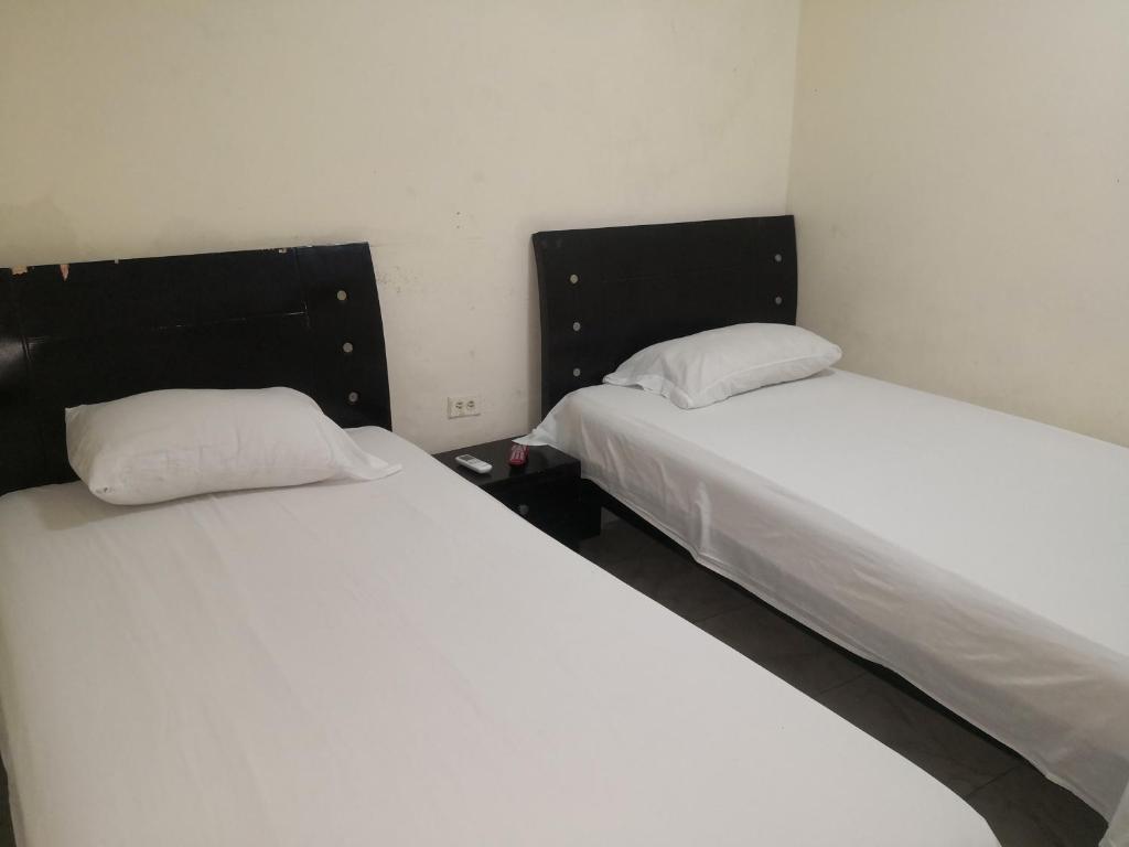 two beds sitting next to each other in a room at Hospedaje el Parque in Soledad
