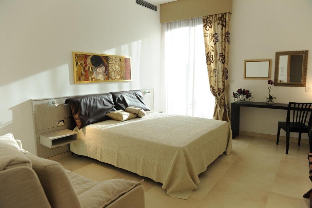 Olo Kalò Locanda في كوريليانو دوترانتو: غرفة نوم بها سرير كبير وأريكة