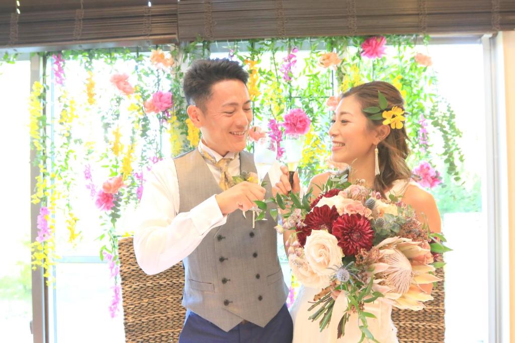 a man and a woman holding a bouquet of flowers at Kerama Terrace in Tokashiki