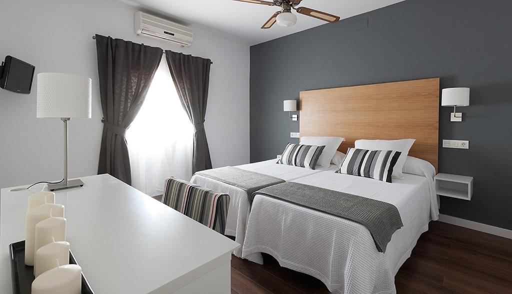 a bedroom with a white bed and a window at Hotel Llorca in Platja de l’Almadrava