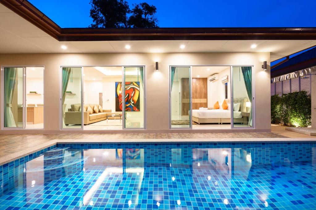 a swimming pool in front of a house at Luxury Pool Villa A18 / 3BR 6-8 persons in Ban Huai Yai