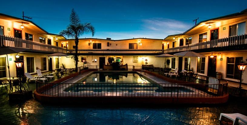 una piscina frente a un edificio por la noche en Hotel Suites Malena en Ensenada
