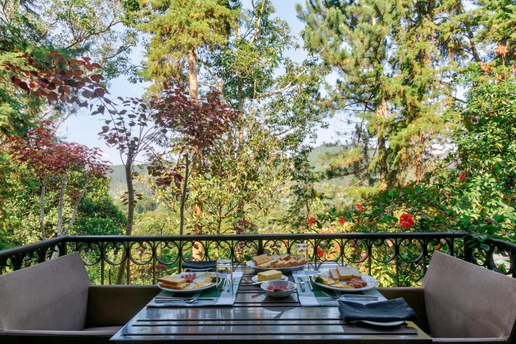 a table with plates of food sitting on a balcony at Villa Republic Bandarawela (04 bedroom) in Bandarawela