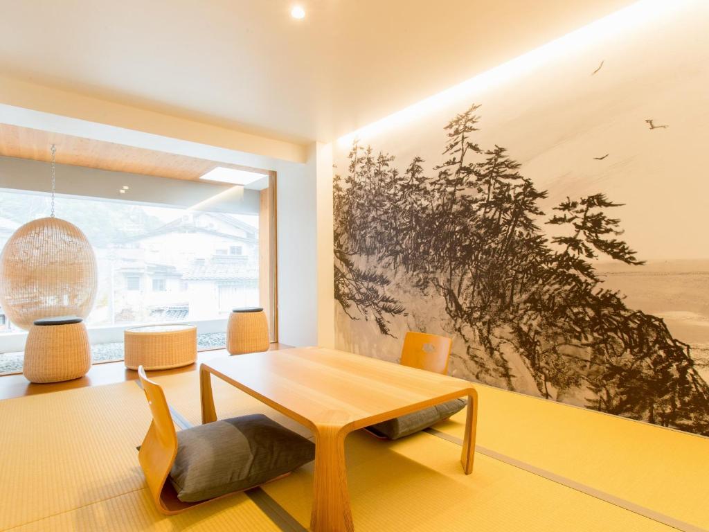 uma sala de estar com uma mesa e uma grande janela em UTSUROI Tsuchiya Annex em Toyooka