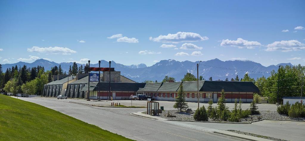 a building on a street with mountains in the background at Crestwood Hotel in Hinton