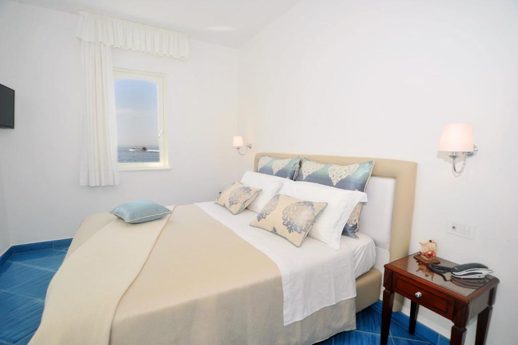a bedroom with a large bed with a window at Core Amalfitano City Suites in Amalfi