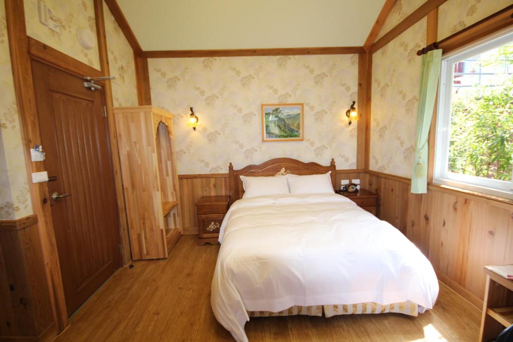a bedroom with a large white bed in it at Cingjing Vienna Pleasance Cottage in Ren&#39;ai