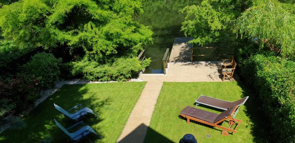 サルバシュにあるKörösparti Paradicsomの椅子とテーブル付きの庭園の景色を望めます。