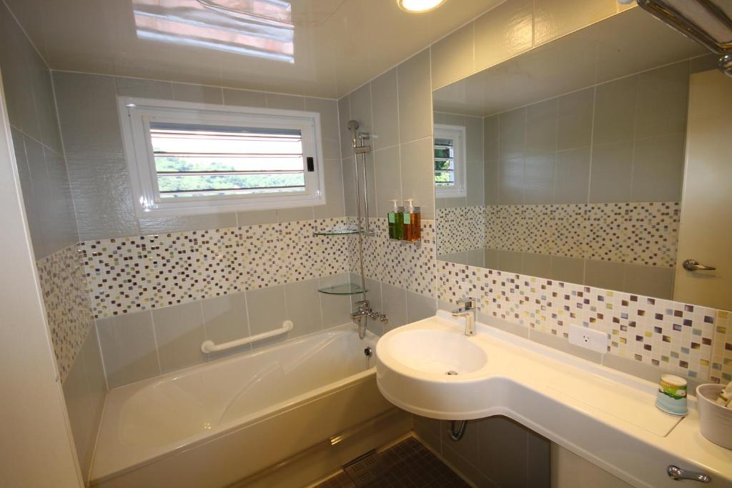 a bathroom with a sink and a bath tub and a sink at Cingjing Vienna Pleasance Cottage in Ren&#39;ai