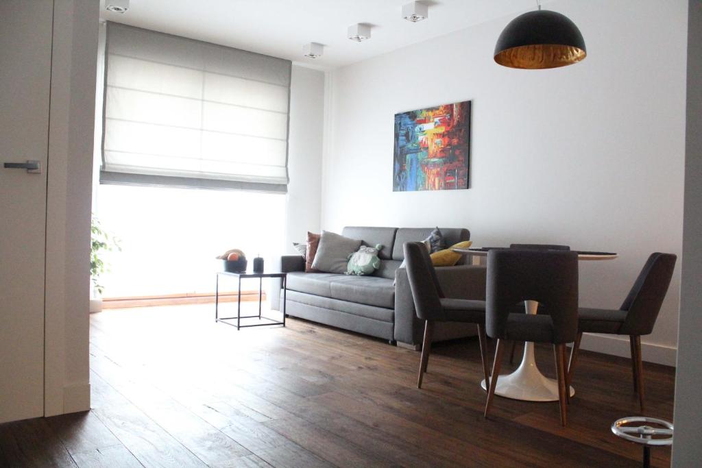 a living room with a couch and a table at Apartament Wilanów Klimczaka in Warsaw