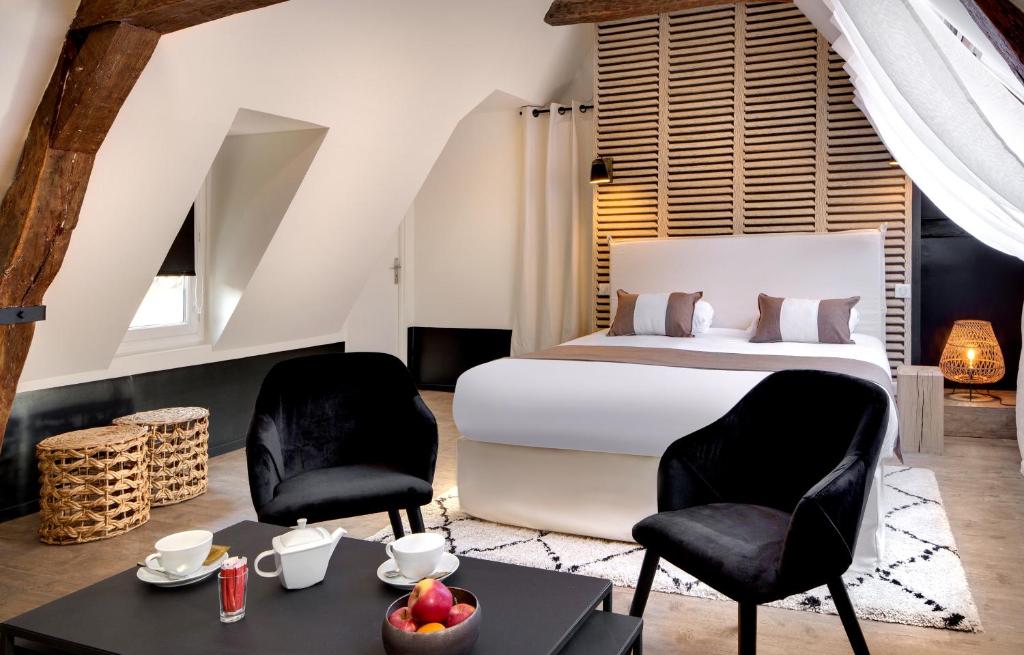 um quarto com uma cama, 2 cadeiras e uma mesa em Maison des Ducs em Dijon