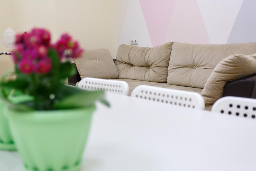 a living room with a couch and a vase of flowers at Re Hostel in Novosibirsk