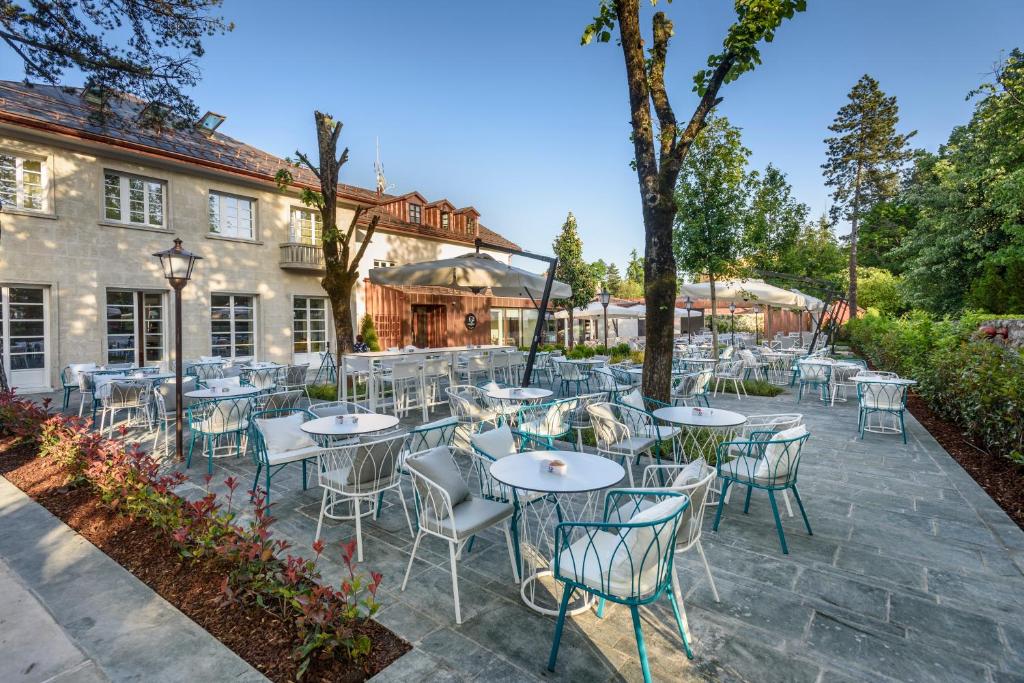 Hotel Gradska Cetinje في ستنيي: فناء فيه طاولات وكراسي امام مبنى
