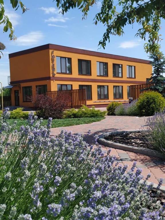 an orange building with flowers in front of it at Смерекова хата in Pavlohrad