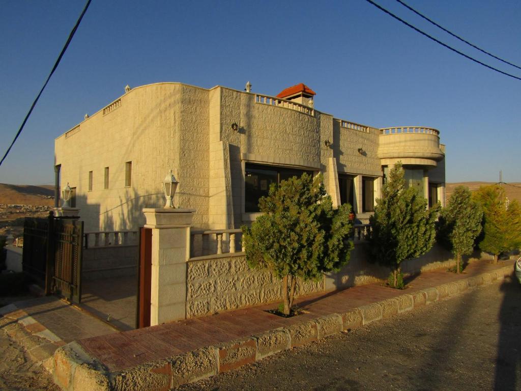 ein großes Gebäude mit Bäumen davor in der Unterkunft Petra Villa in Wadi Musa