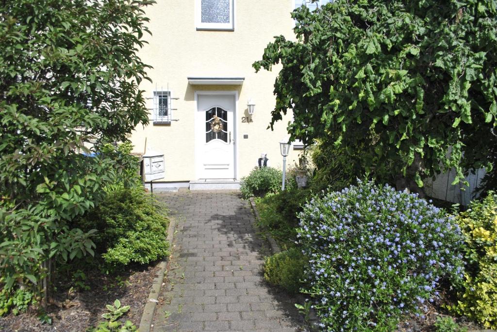 ein weißes Haus mit einem Weg, der zu einer Tür führt in der Unterkunft gemütliche Zimmer im Einfamilienhaus in Köln