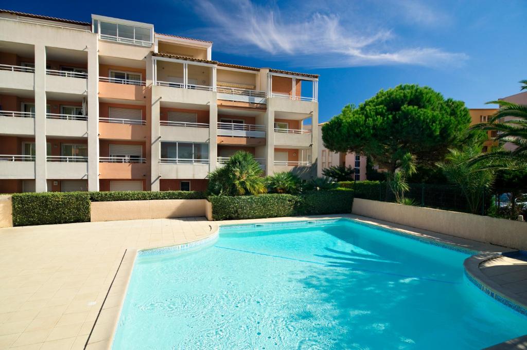 - une piscine en face d'un immeuble dans l'établissement Vacancéole - Savanna Beach- Terrasses de Savanna, au Cap d'Agde