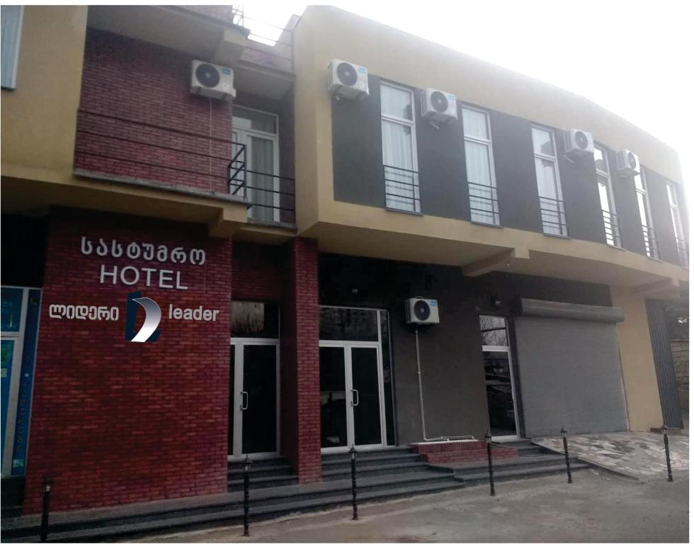 a hotel with a sign on the side of a building at Hotel LEADER in Tbilisi City