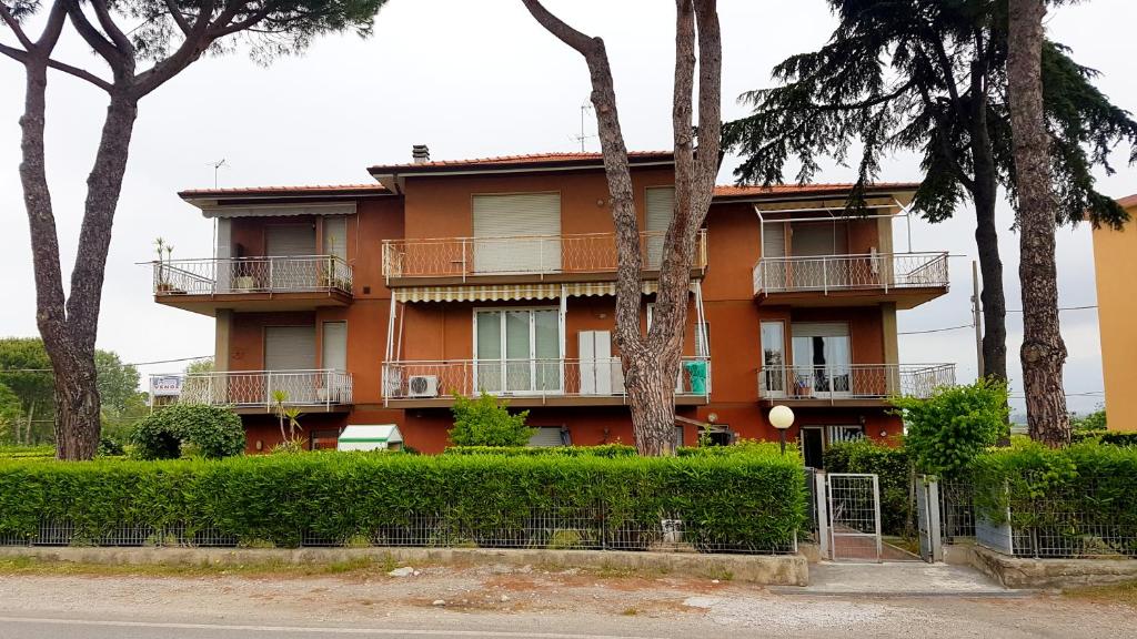 an orange building with trees in front of it at Apt. 7 - Villa dei Pini in Ameglia