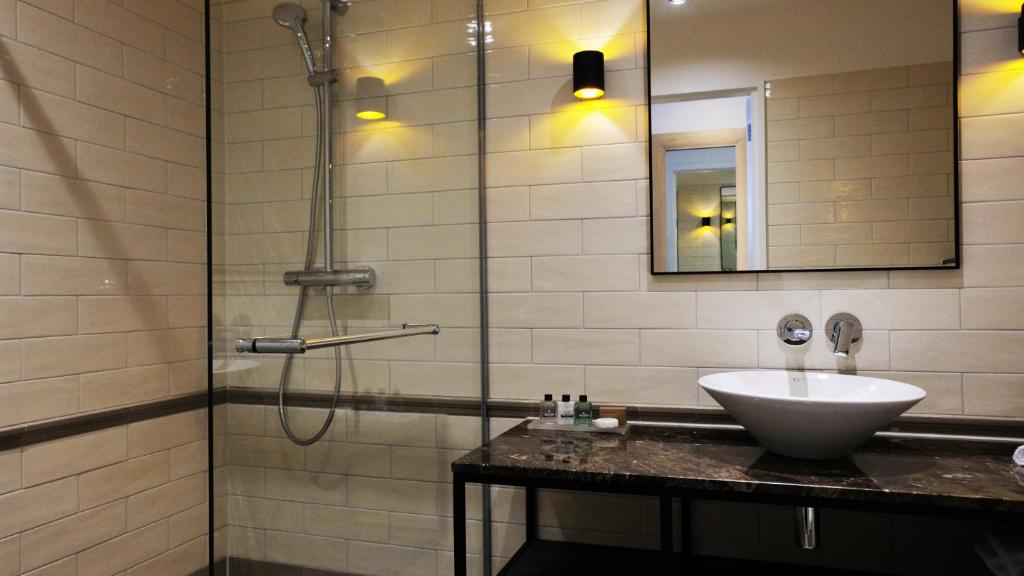 a bathroom with a sink and a shower at Hotel New York by WestCord in Rotterdam
