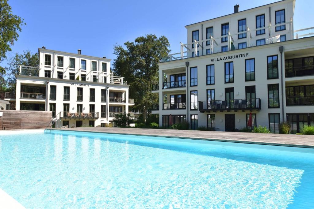 a large swimming pool in front of a building at Binzer Parkvillen in Binz