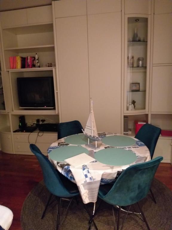 une table à manger avec quatre chaises et une télévision dans l'établissement Piers de Raveschootlaan, à Knokke-Heist
