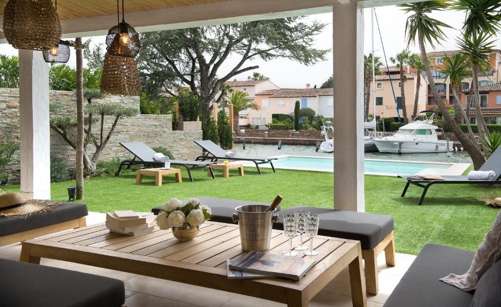 sala de estar con mesa y vistas a la piscina en Villa Lostan, en Grimaud