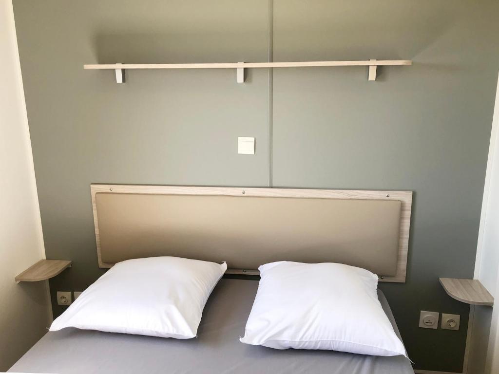 dos almohadas blancas sentadas en una cama en una habitación en Aria Marina en Meria