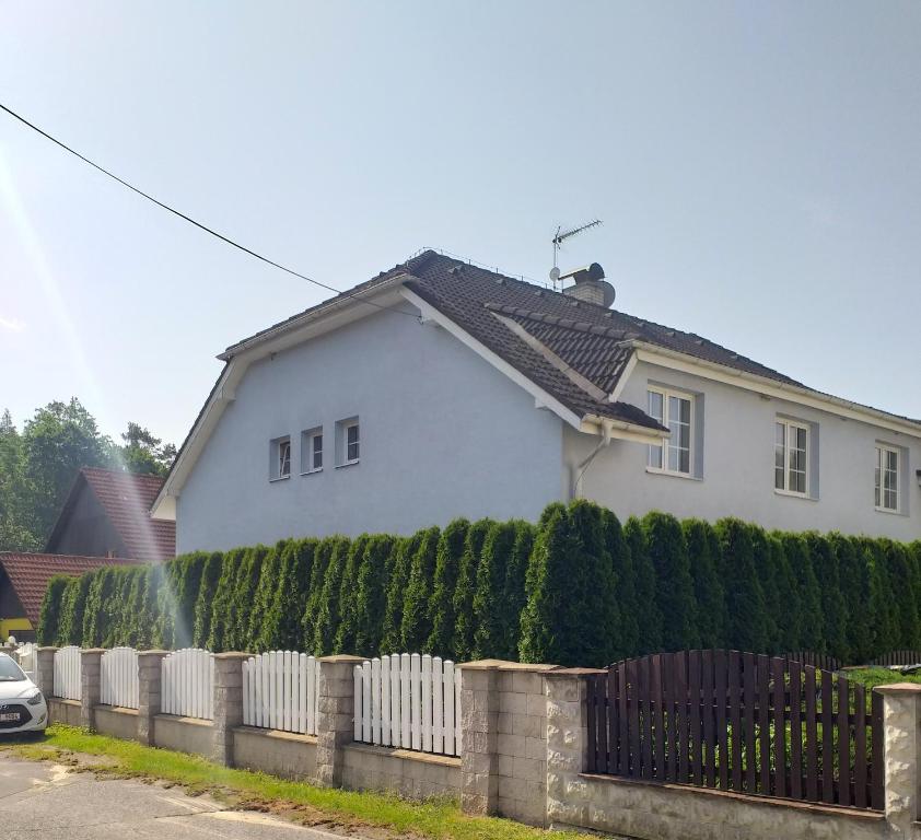 a white house with a fence in front of it at Vila Terezie in Staré Splavy