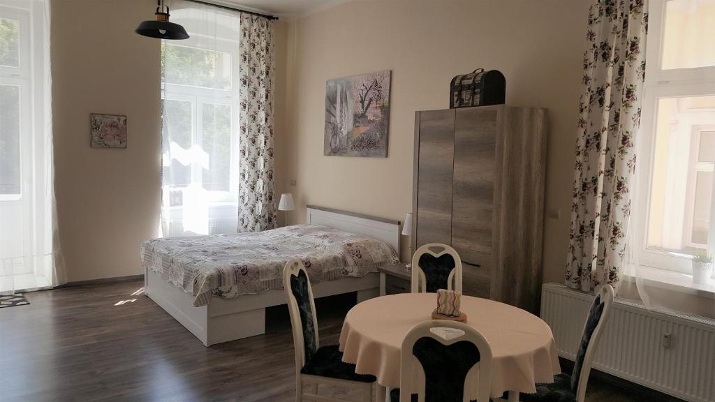 マリアーンスケー・ラーズニェにあるApartment Marienbad Hlavni 131/50のベッドルーム1室(ベッド1台、テーブル、椅子付)