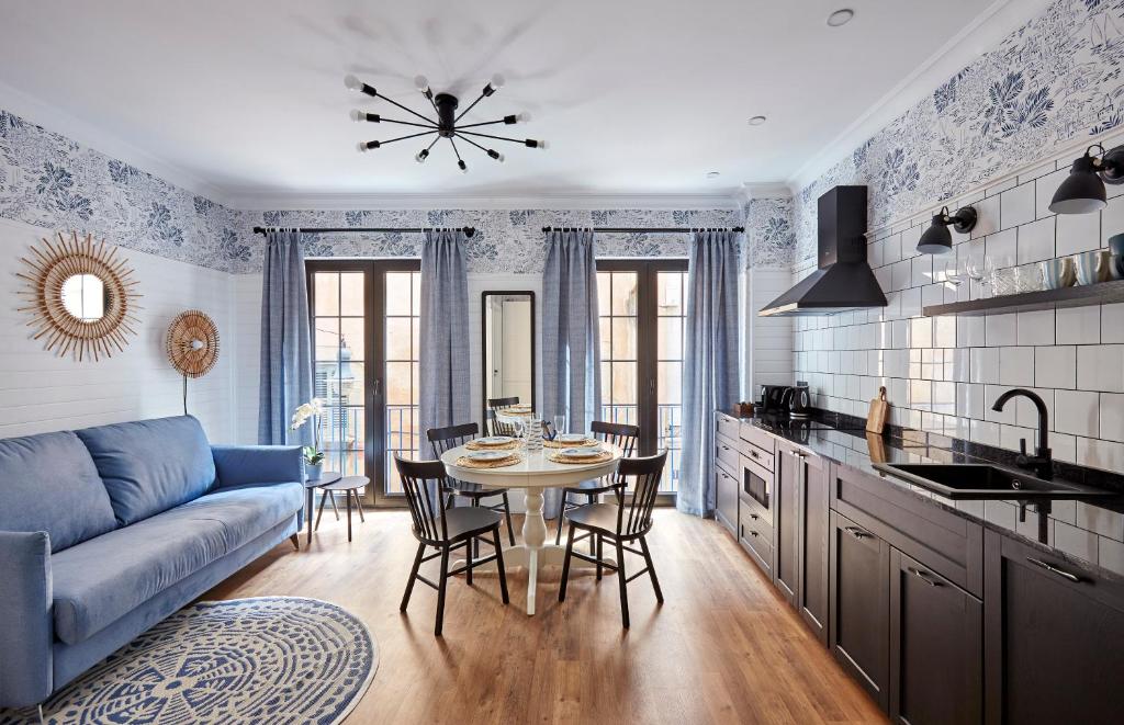 a living room with a table and a blue couch at "Breeze" Aparthotel by Parrot`s House in Lloret de Mar