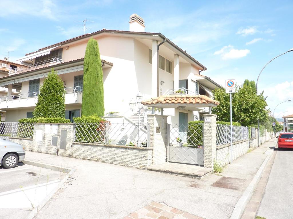 a white house on a street with a fence at Dimora Rinaldi in Empoli