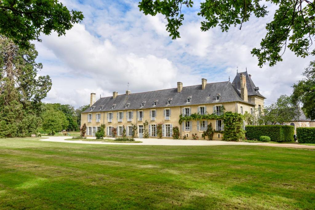 una casa grande con un gran patio de césped en Chateau de la Villedubois en Mordelles