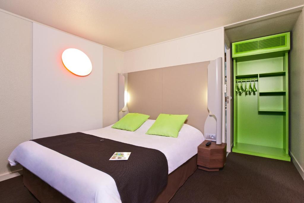 1 dormitorio con 1 cama grande con detalles verdes en Campanile Le Havre Nord - Montivilliers, en Montivilliers