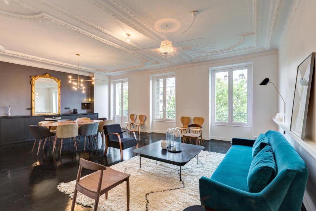 een woonkamer met een blauwe bank en een tafel bij Drouot Luxe in Parijs