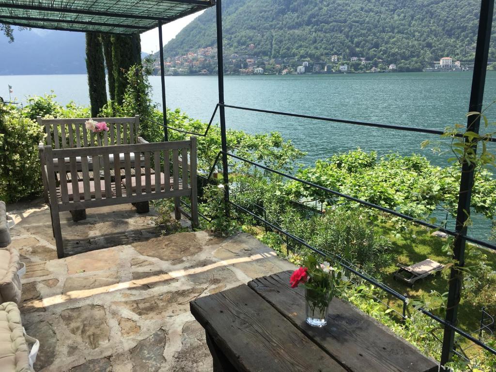 eine Bank auf einem Tisch neben einem See in der Unterkunft Casa Vacanza Castagna in Nesso