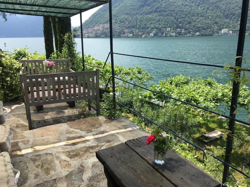 un banco sentado en una mesa junto a un lago en Casa Vacanza Castagna, en Nesso